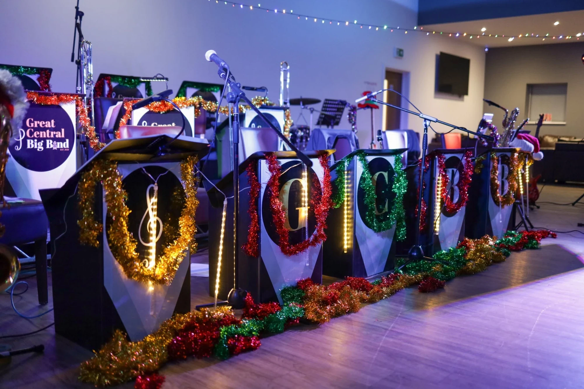 The band's music stands on stage, wrapped in red, gold and green tinsel, spelling out a treble clef and G C B B